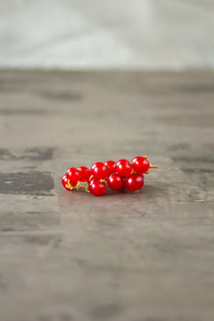 Red currants scattered over a gray texture background. High quality photoの写真素材