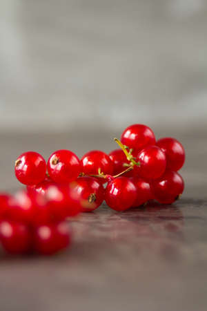 Red currants scattered over a gray texture background. High quality photo