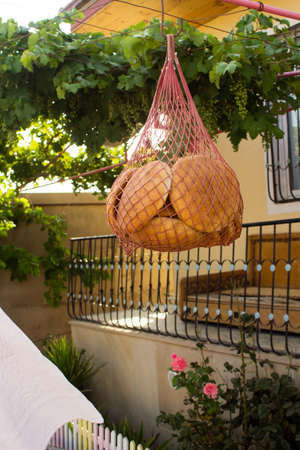 Round white bread hanging in a grid for drying