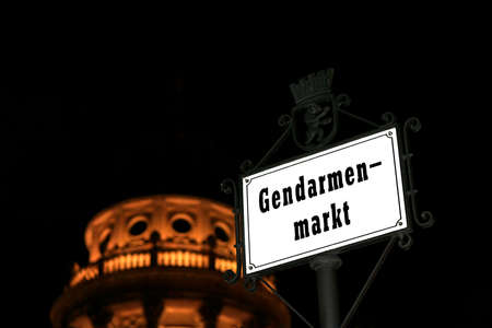 Signpost Gendarmenmarkt in Berlin, capital of  Germany, with French cathedral by nightの写真素材