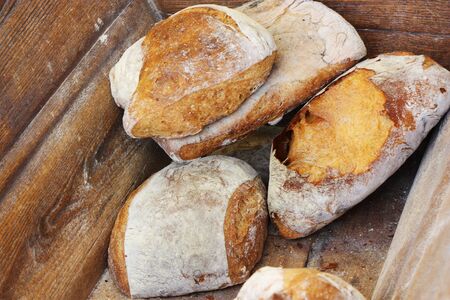 Traditional French bread for sale in a wooden bin in a rural bakery.