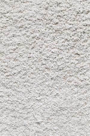White roughcast lime mortar plaster wall background texture with a rough gritty crepi  finish on an old historic building made from a mixture of lime and coarse sand in the old tradition in a full frame viewの写真素材