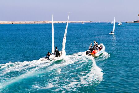 Heraklion Crete Greece Nov 3, 2013. Unexpected sailing accident  the collision of two training boats towed by a high speed vessel , and the obviously worried trainers staring back at the trainees.のeditorial素材