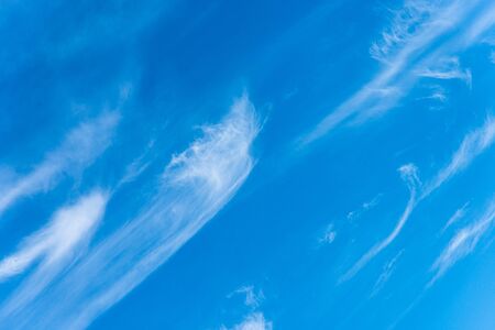Panoramic view of blue sky with sparse thin swirls of white delicate near transparent clouds