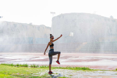 Young woman ready for fitness training in local sports stadium.