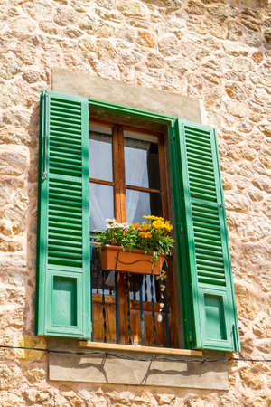 Traditional stone wall window with ceramic flower pot decorations in Valdemossa village, Mallorca, Spainの写真素材