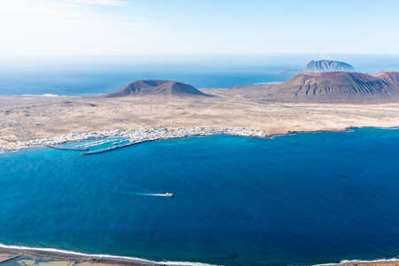 Unique panoramic magnificent aerial view of volcano cone at volcanic island La Graciosa south coast, in Atlantic ocean, from Mirador del Rio, Lanzarote, Canary Islands, Spain. Travel concept.の写真素材