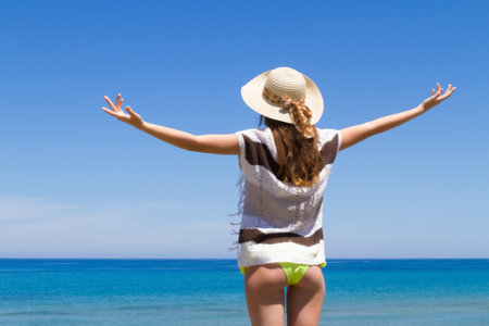 Young carefree happy woman feeling blissful, enjoyes summer on peaceful beach. Stress free, relaxation, freedom wellness, happiness conceptの写真素材