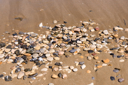 Smooth colorful wet pebble stones background on the beach.の写真素材