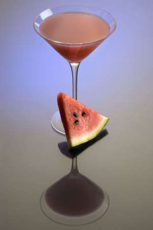 Watermelon Martini mixed drink with melon garnish on grey background with reflectionの写真素材