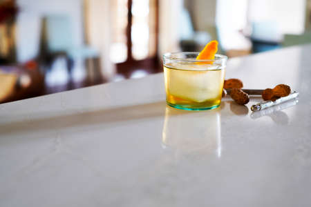 Tequila Old-fashioned Cocktail with an orange twist and an accompaniment of peanutsの写真素材