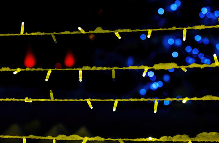 Christmas background with festive decor, colorful garland. On the back black background, the bokeh is multicolored.の写真素材