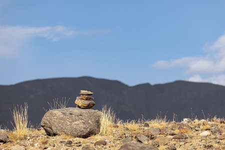 A pyramid of stones in the mountains against the blue sky, the balance of stones, harmony and meditation.の写真素材