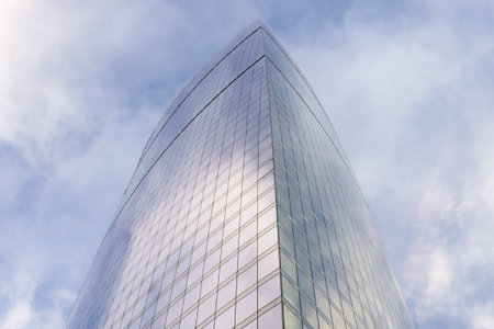 Modern skyscrapers in close-up with a wide angle against a background of blue sky with clouds in the...