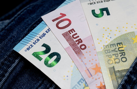 Euro banknotes of different denominations in a jeans pocket close-up.