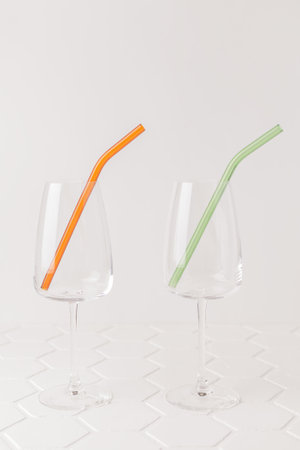 Colorful reusable glass straws in the glass on white background. An alternative replacement for classic disposable plastic drinking straw, eco-friendly, zero waste. Cope space for text.の写真素材