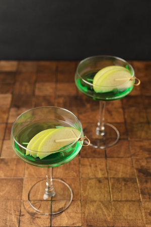 Classik Apple martini - appletini, cold summer cocktail with gin, apple liqueur, dry vermouth and ice on the black background. Copy space for text. High quality photoの写真素材