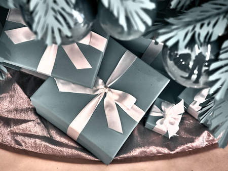 Shot of a group of boxes with presents under a decorated Christmas treeの写真素材