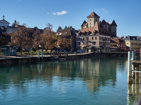 Annecy, France - December 07, 2018: View of the river "Le Thiou", an effluent of the lake of Annecy, and the Castle in the background. The river runs along the "Jardins de l'Europe", the famous garden in Annecy. People are relaxing during the sunny dayのeditorial素材
