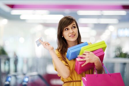 Beautiful woman with credit card in shopping mallの写真素材