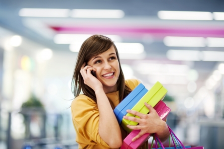 Beautiful woman on the phone in shopping mallの写真素材