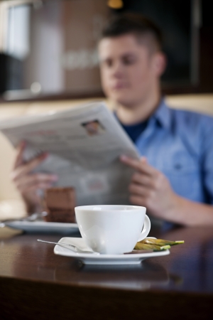 Reading newspaper in cafeの写真素材