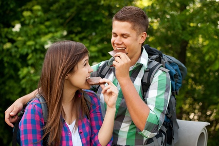Young couple eating chocolate in forestの写真素材