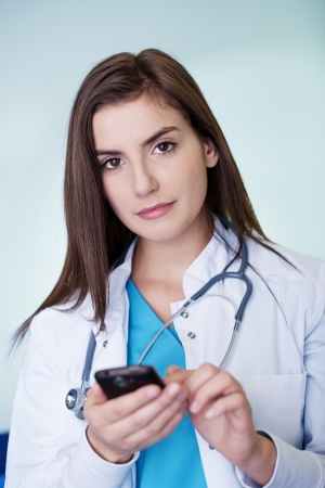 Young female doctor textingの写真素材