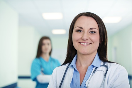 Portrait of young female doctor with intern in backgroundの写真素材