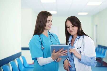 Female doctors checking results on digital tabletの写真素材