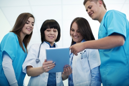 Medical team checking results on digital tabletの写真素材