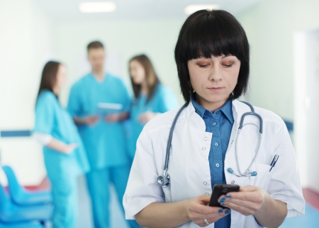 Portrait of female doctor with interns in backgroundの写真素材
