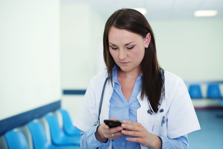 Young female doctor textingの写真素材