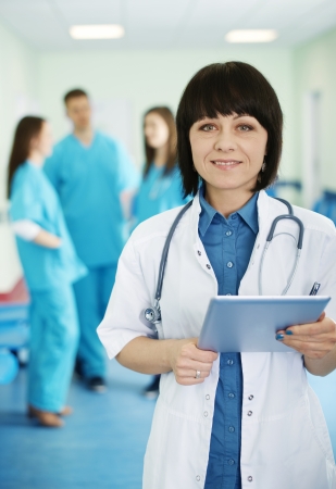Portrait of female doctor with interns in backgroundの写真素材