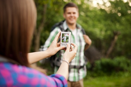 Young woman taking photo for her boyfriendの写真素材
