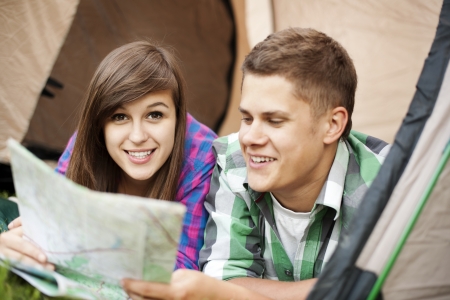 Couple looking at map in tentの写真素材