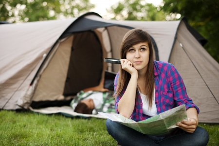 Beautiful young woman sitting in front of tentの写真素材