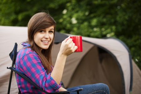 Young woman sitting in front of the tentの写真素材