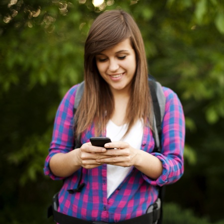 Beautiful female hiker textingの写真素材