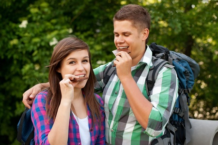 Young couple eating chocolate in forestの写真素材