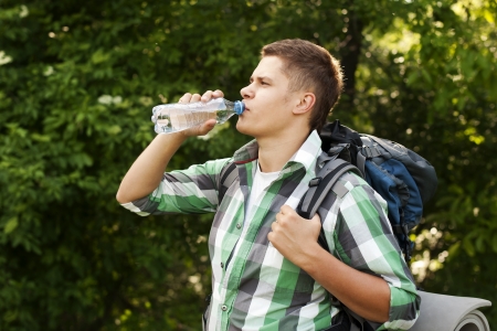 Hiker drinking water in forestの写真素材