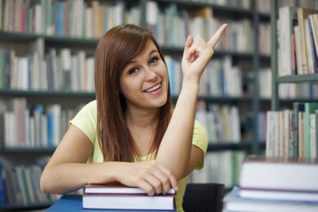 Beautiful student pointing at copyspaceの写真素材