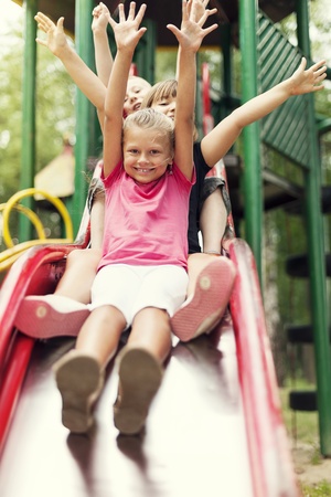 Happy kids slide on playgroundの写真素材
