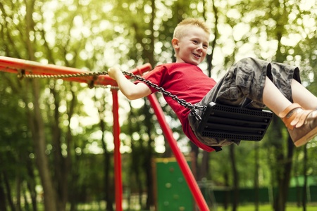 Cute boy swinging in a parkの写真素材