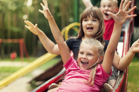 Happy kids playing on slideの写真素材