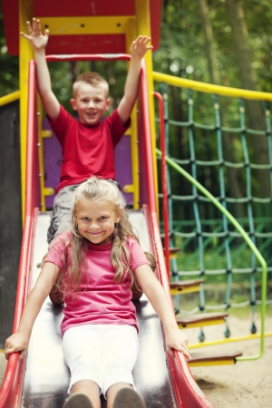 Two kids having fun on slide の写真素材