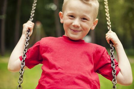 Close-up of little boy swingingの写真素材