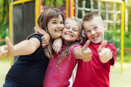 Happy children showing ok sign on playgroundの写真素材