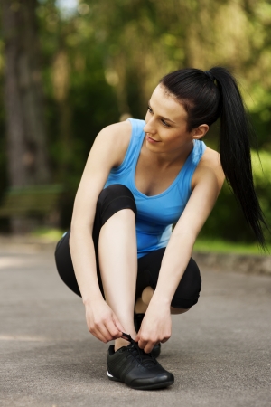 Young woman tying sports shoeの写真素材