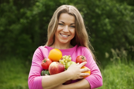 Young woman holding fruits and vegetablesの写真素材